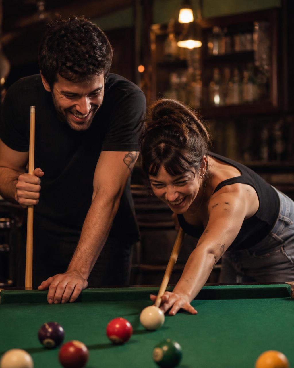 Two teammates laughing while playing doubles pool at a bar table