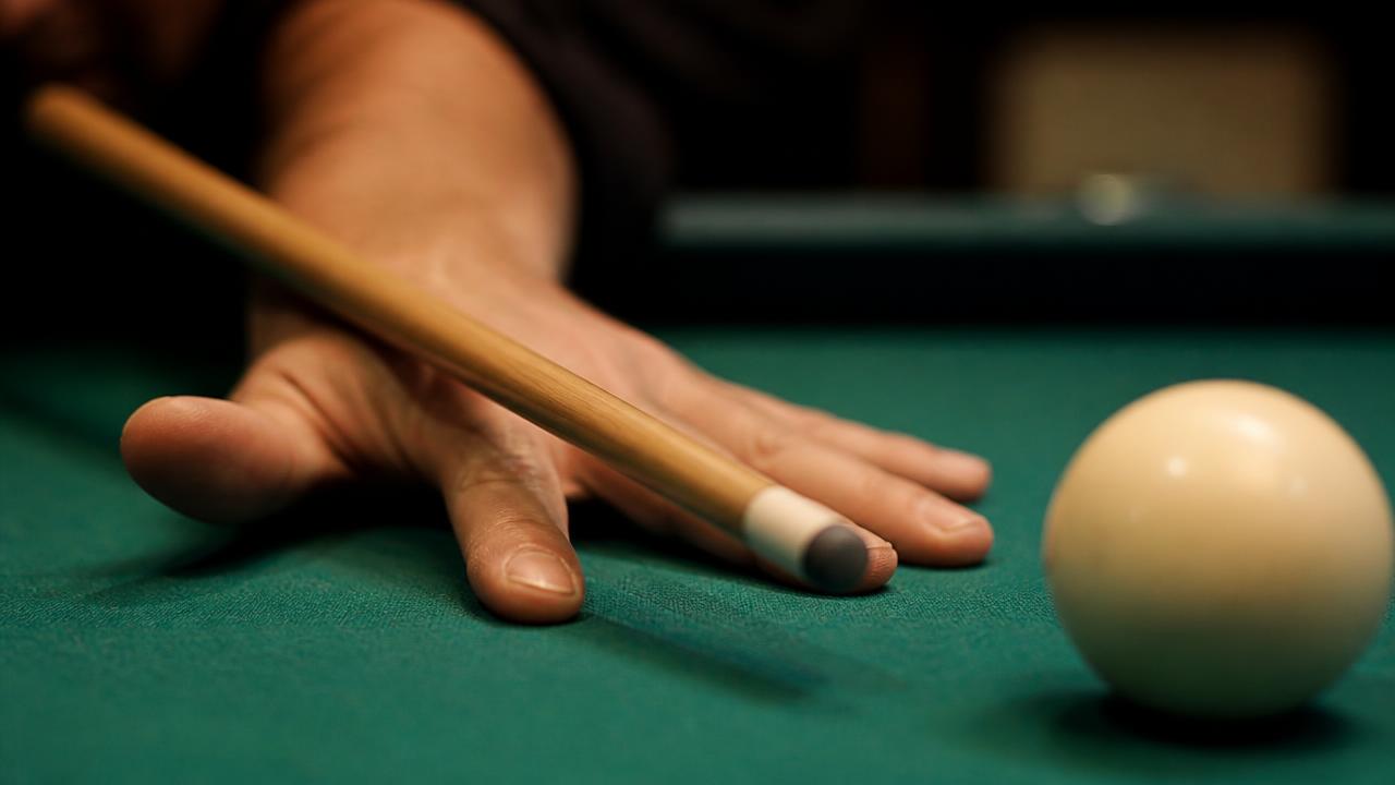 Close up of a player's open bridge hand with a cue resting through it